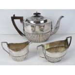 A Victorian HM silver tea service, tea pot with wooden handle and finial,