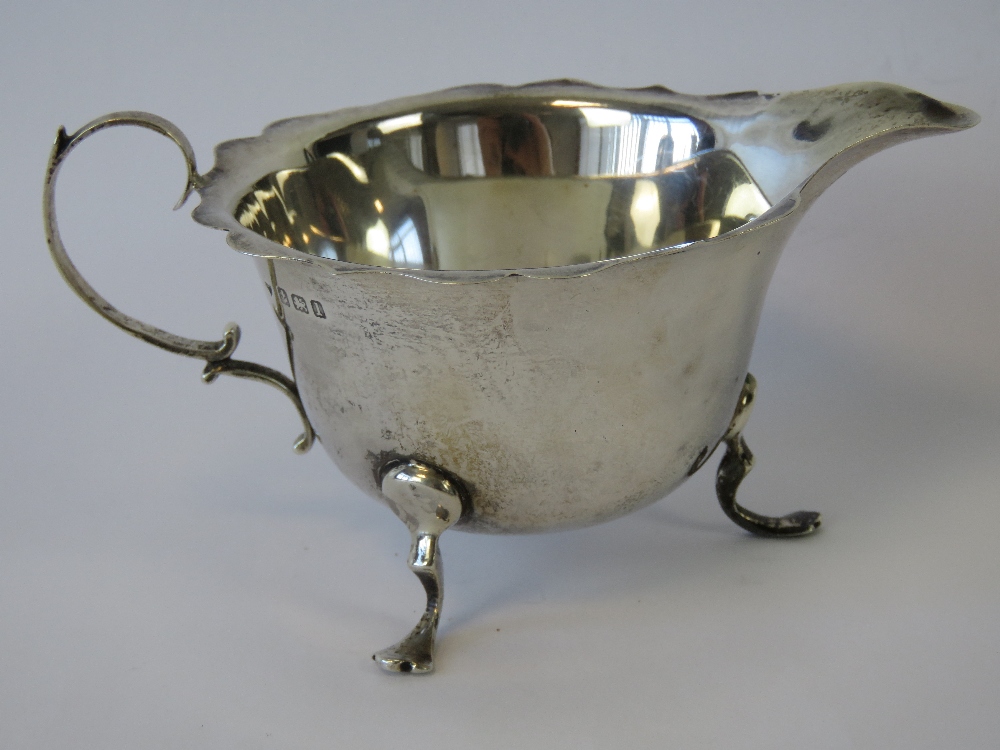 A HM silver jug with pie crust rim, raised over three outswept feet, 2.21ozt.