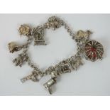 A Sterling silver curb link charm bracelet with eleven charms including; enamel lobster in pot,