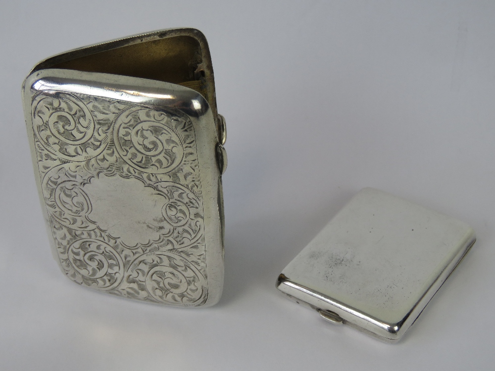 A HM silver cigarette case with foliate engraving, gilded interior, two elasticated straps,