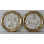 A pair of Victorian style ivory ground moulded relief plaques in the Classical style,