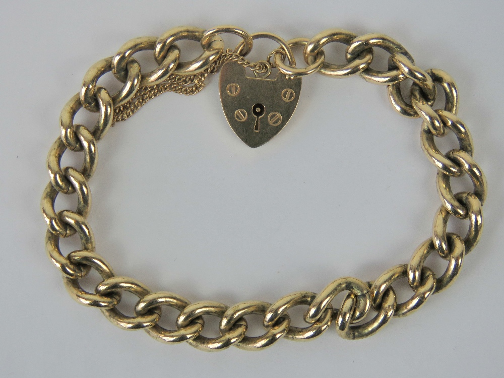 A heavy 9ct gold curb link bracelet with heart padlock clasp, hallmarked 375, 40.2g.