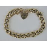 A heavy 9ct gold curb link bracelet with heart padlock clasp, hallmarked 375, 40.2g.