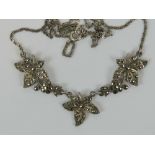 A vintage silver and marcasite necklace in the form of three leaves,