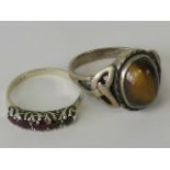 Two silver rings; one five graduated red stone ring, size I-J,and one with oval tigers eye cabachon,