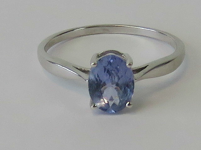 A 9ct white gold ring with solitaire oval cut blue gemstone, hallmarked 375, size R, 2g.