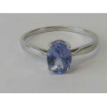 A 9ct white gold ring with solitaire oval cut blue gemstone, hallmarked 375, size R, 2g.