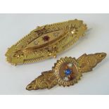 Two 9ct gold brooches, one with diamonds and red stone in star settings, glass panel to back,