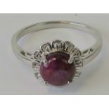 A silver ring of floral design with central ruby matrix cabachon, stamped 925, size Y-U.