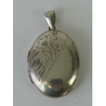 A silver locket of oval form with floral engraving to front, stamped 925, 4.5cm including bale.