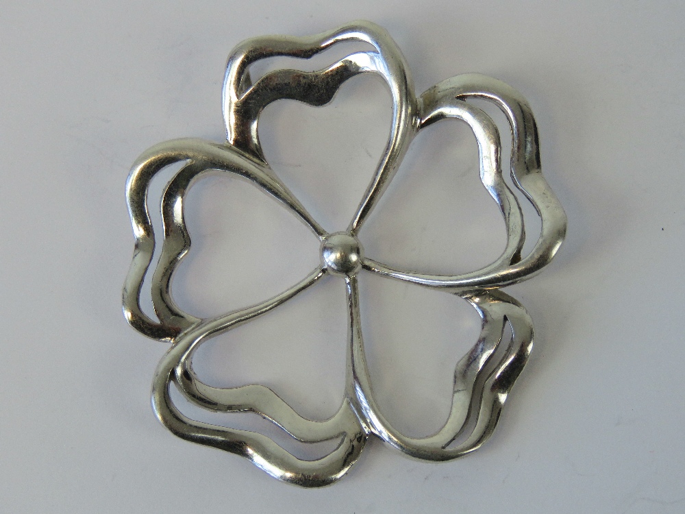 A silver pendant in the form of a five petalled flower, double bale to back, stamped 925, 5.5cm dia.