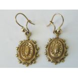 A pair of Victorian yellow metal earrings complete with hangers, 1.3g.