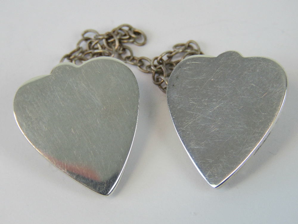 A pair of sterling silver collar clips, complete with chain.