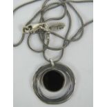 A silver pendant of open circular form with onyx panel, stamped 925 Israel,