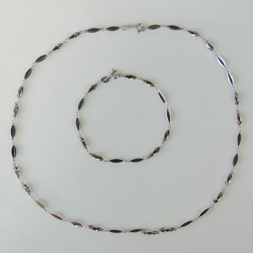 A silver necklace and bracelet set, each