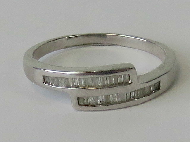 A silver crossover ring set with baguett