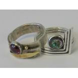 Two silver rings of abstract design; one