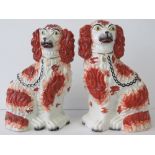 A pair of reproduction Staffordshire seated opposing Spaniels, each standing 26cm high.