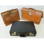 Two vintage brown leather brief cases and a modern black attaché case, three items.