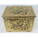 A brass covered log box with embossed scene depicting dogs,