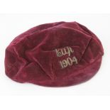 An Edwardian red velvet sports cap with braid inscription 'Cup 1904',