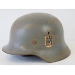 A WWII German helmet with double decal, handwritten name within, replacement liner and chin strap,