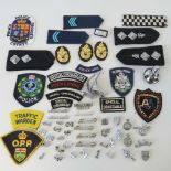 A large quantity of assorted police badges and helmet fittings including;