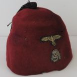 A rare WWII German Waffen SS 13th Handschar Division maroon fez cap with Totenkopf skull & eagle.