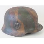 A fine replica of a WWII German helmet with SS double decal and Austrian style camo paint having