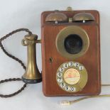 A vintage wall mounted dial telephone having brass dial, brass ear and mouthpiece,