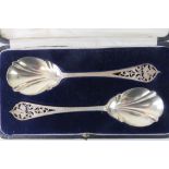 A pair of HM silver serving spoons with pierced foliate design handles and shaped bowls,