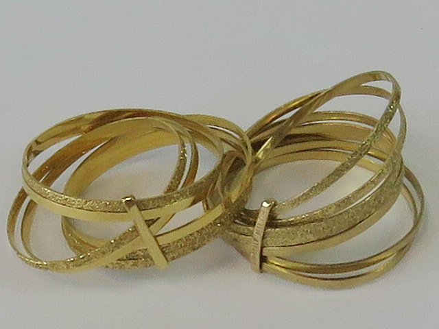 Two 9ct gold sets of stacked rings, each comprising seven thin bands, both marked 9kt,