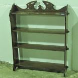 A floor standing four shelf bookcase of pegged form and with fretted decorative top, 71cm wide.