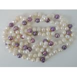 A long strand of baroque pearls, lilac and white hues,