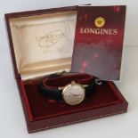 A 9ct gold Longines wristwatch complete with certificate, service book and presentation box.