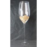 A large and impressive freestanding perspex wine glass complete with quantity of corks within,