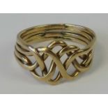 A yellow metal jigsaw ring formed from four interlinked bands, size O, 3.9g.