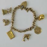 A 9ct golf curb link charm bracelet having two attached 9ct gold charms,