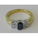 An 18ct gold sapphire and diamond ring, central emerald cut royal blue sapphire approx 0.