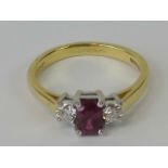 An 18ct gold ruby and diamond ring, central emerald cut ruby approx 0.