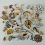 A quantity of assorted 20th century costume brooches.