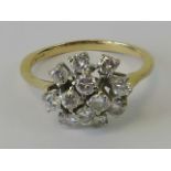 An 18ct gold and diamond cluster ring, twelve round cut brilliant diamonds claw set in white metal,