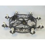 A heavy modern wrought iron circular pendant light fitting with eight candle sconce branches,