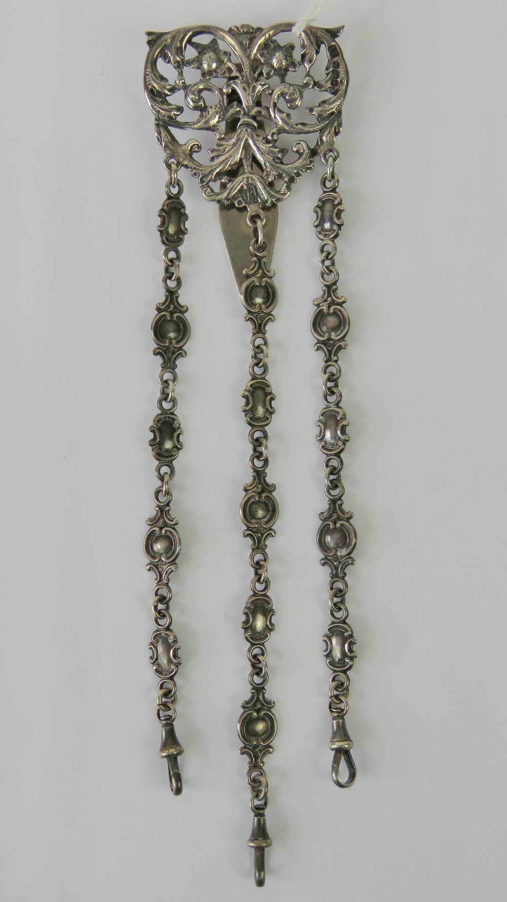 A HM silver chatelaine complete with hinged belt hook and three chains terminating in dog clasps,