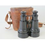 A good pair of Edwardian field glasses in a leather case,