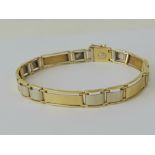 An 18ct white and yellow gold alternating panel bracelet, stamped 750 with single Arabic hallmark,