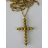 A 9ct gold long fancy link chain having yellow metal bead cross upon,