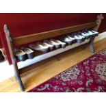 A reclaimed Victorian Gothic Revival oak pew frame converted for use as a shoe rack and measuring