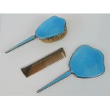 A HM silver and enamelled three piece dressing table set comprising mirror, hairbrush and comb,