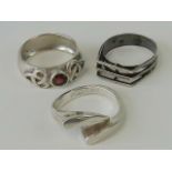 Three silver rings; a Celtic design band with round cut red stone stamped 925, size O,